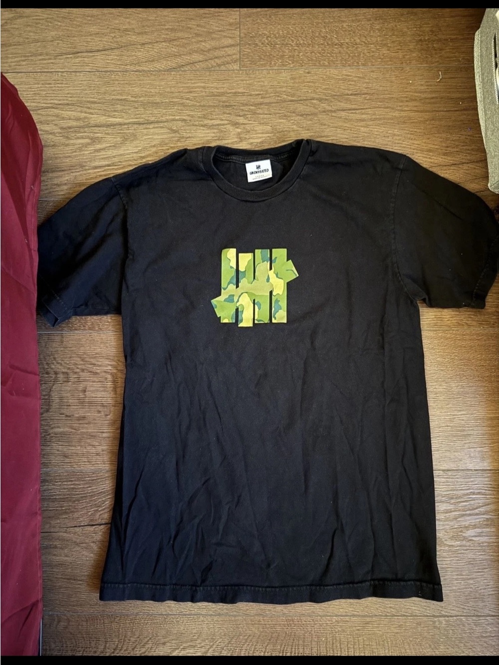 Undefeated Black Tee with Green Camo Logo